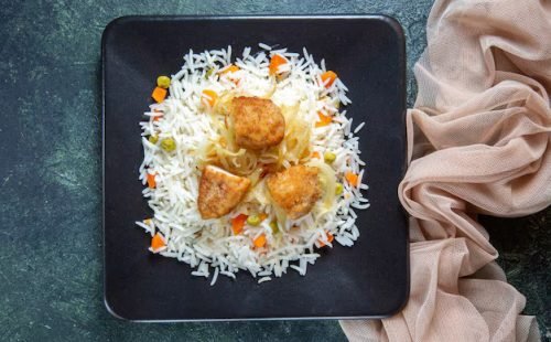 top-view-tasty-boiled-rice-with-beans-meat-inside-plate-dark-desk_179666-27241